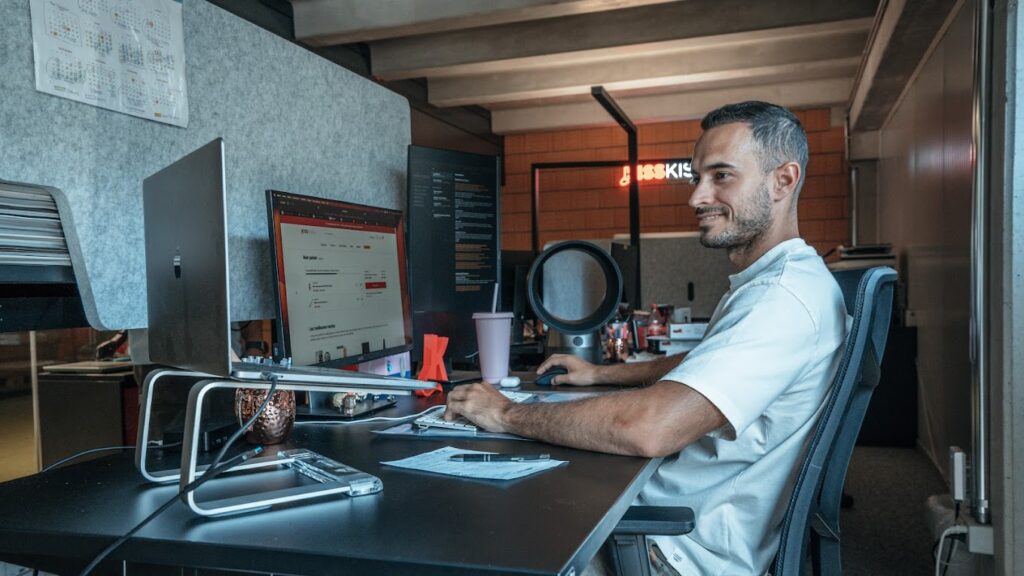 an employee (dev) of KissKiss working in his office
